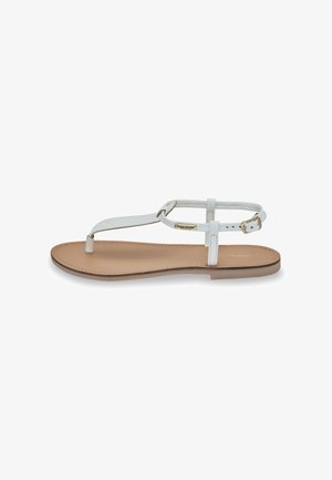 White leather sandals with minimalist design, featuring a toe post and ankle strap. Flat beige sole, single buckle for adjustment.
