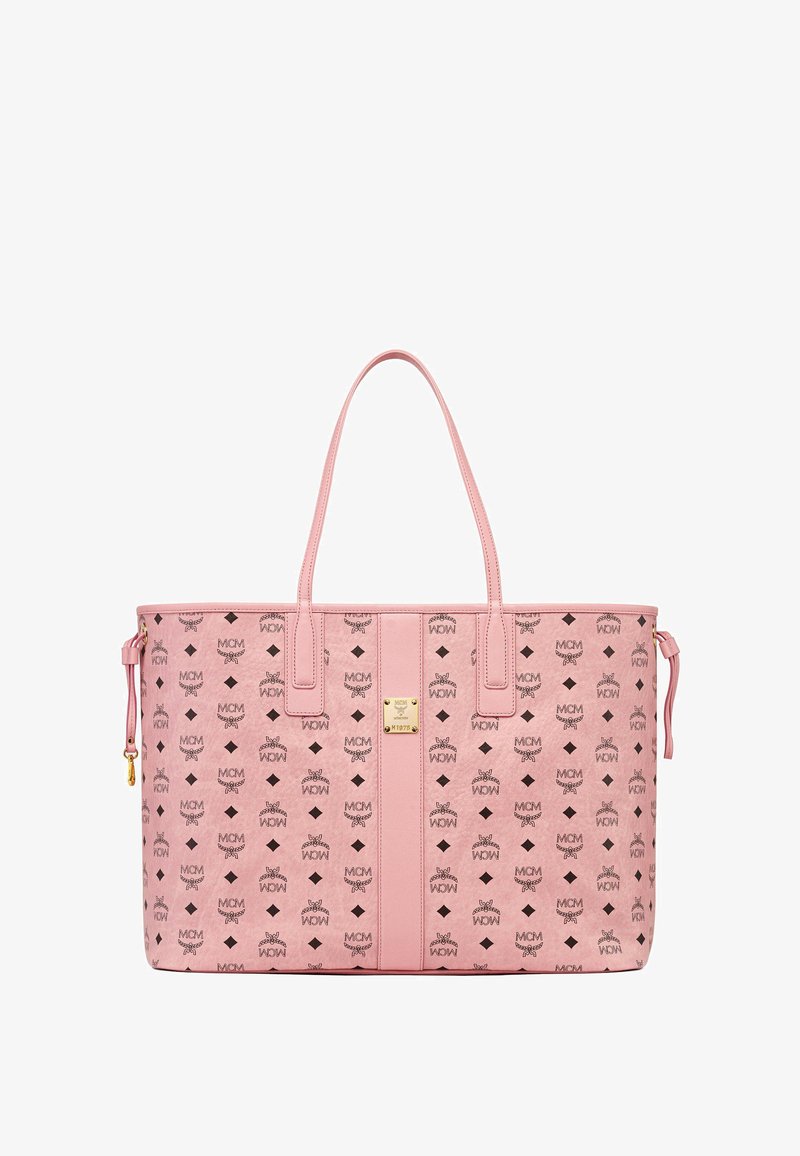 Rozā somiņa, izgatavota no ādas, ar logotipa rakstu. Tam ir divas izturīgas rokas un zelta tonēta metāla akcents uz priekšpuses.