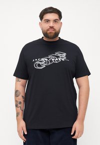 Juodas trumpomis rankovėmis marškinėliai su balta grafika ir užrašu "JACK & JONES". Pagaminti iš minkštos medžiagos, su laisvu siluetu.