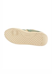 Suola delle scarpe con un motivo a diamante testurizzato, di colore crema, caratterizzata da un tacco arrotondato e un logo del marchio impressa. Accenti verdi visibili sui lati.