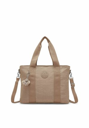 Beige rectangular tote bag with two shoulder handles, detachable long strap, round logo patch, and small monkey keychain attached.