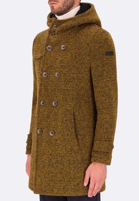 Cappotto di lana a fantasia giallo-marrone con cappuccio, design doppiopetto, grandi bottoni e tasca sul petto. Tessuto texture e vestibilità su misura.