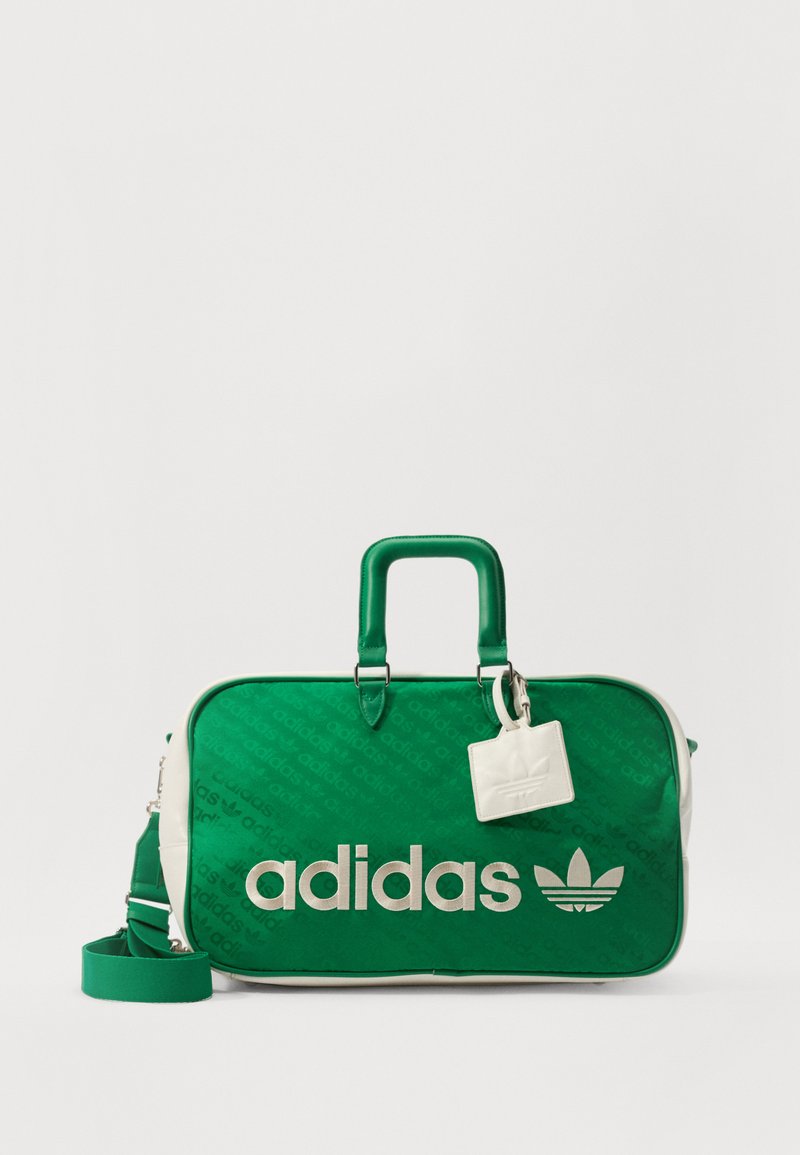 Mala de desporto Adidas verde com detalhes brancos, material texturizado, grande logotipo, alças superiores, tira destacável e uma pequena etiqueta com emblema.