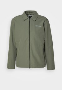 Olive green zip-up jacket with collar, long sleeves, side pockets, and "core dept." logo on left chest.
