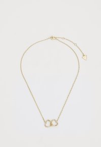 Gouden ketting met een hartvormige hanger waarop kleine, ingebedde edelstenen zijn bevestigd, en een driehoekige charme aan de sluiting.