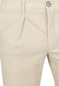 Beige ribfluwelen broek met smalle verticale strepen, voorzien van een knoopsluiting aan de voorkant en zijzakken. Gestructureerde stof met een zachte afwerking.