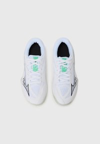 White athletic shoes with mesh panels, black accents, and green detailing on the tongue. Features flat white laces and a textured sole.