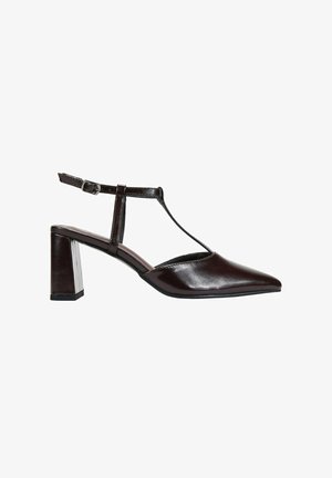 Zapato de charol marrón tipo slingback con puntera afilada, diseño de tira en T y tacón cuadrado. Cuenta con una hebilla para un ajuste ajustable.