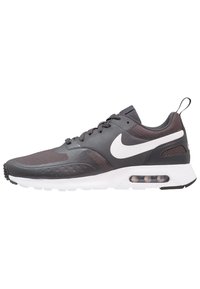 Nike Air Max shoes, featuring a black upper with textured accents, white sole, prominent Swoosh logo, and visible air cushioning unit.