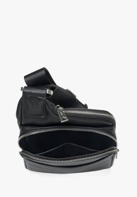 Černá kožená crossbody taška s několika zipovými přihrádkami, s texturovaným povrchem a hladkým černým látkovým interiérem. Nastavitelný popruh.