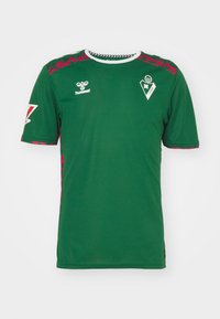 Zielony sportowy t-shirt z krótkim rękawem i białym okrągłym dekoltem, z różowymi wzorzystymi akcentami na ramionach oraz logo na klatce piersiowej.