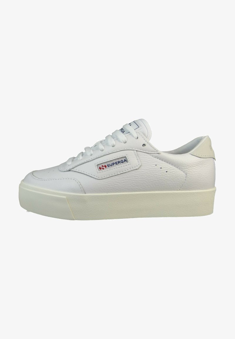 White leather sneaker with a textured surface, round toe, flat white laces, and a stacked rubber sole. Features a red and blue logo patch.
