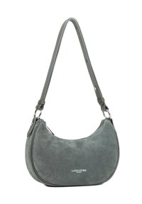 Borsa a tracolla a forma di mezzaluna in suede grigio con tracolla regolabile e zip argentata, con il marchio "Lancaster Paris" sul fronte.