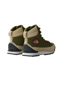 Botas de senderismo verdes y beige con diseño de cordones, collar acolchado, suela de goma y una insignia de logo púrpura en el costado. Acentos de tela texturizada.