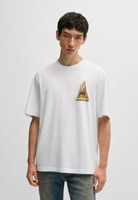 Weißes Baumwoll-T-Shirt mit einem bunten, gestickten Augendesign in Form einer Pyramide auf der linken Brust. Kurze Ärmel, lässiger Schnitt.