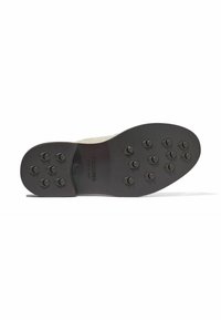 Suola di scarpa in gomma nera con più battistrada circolari e branding in rilievo. Texture liscia con una leggera lucentezza e bordi rinforzati.