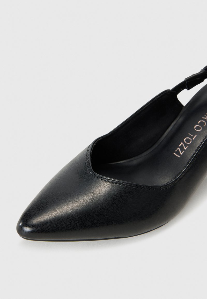Czarne buty na obcasie z wąskim noskiem, wykonane z gładkiej skórzanej cholewki, z otwartym tyłem i minimalnymi detalami w szyciu. Posiadają smukły obcas oraz elegancki design.