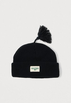 Zwarte gebreide beanie met een omgeslagen boord, voorzien van een decoratieve pompon bovenop en een rechthoekig logo-opdruk in groen en wit.
