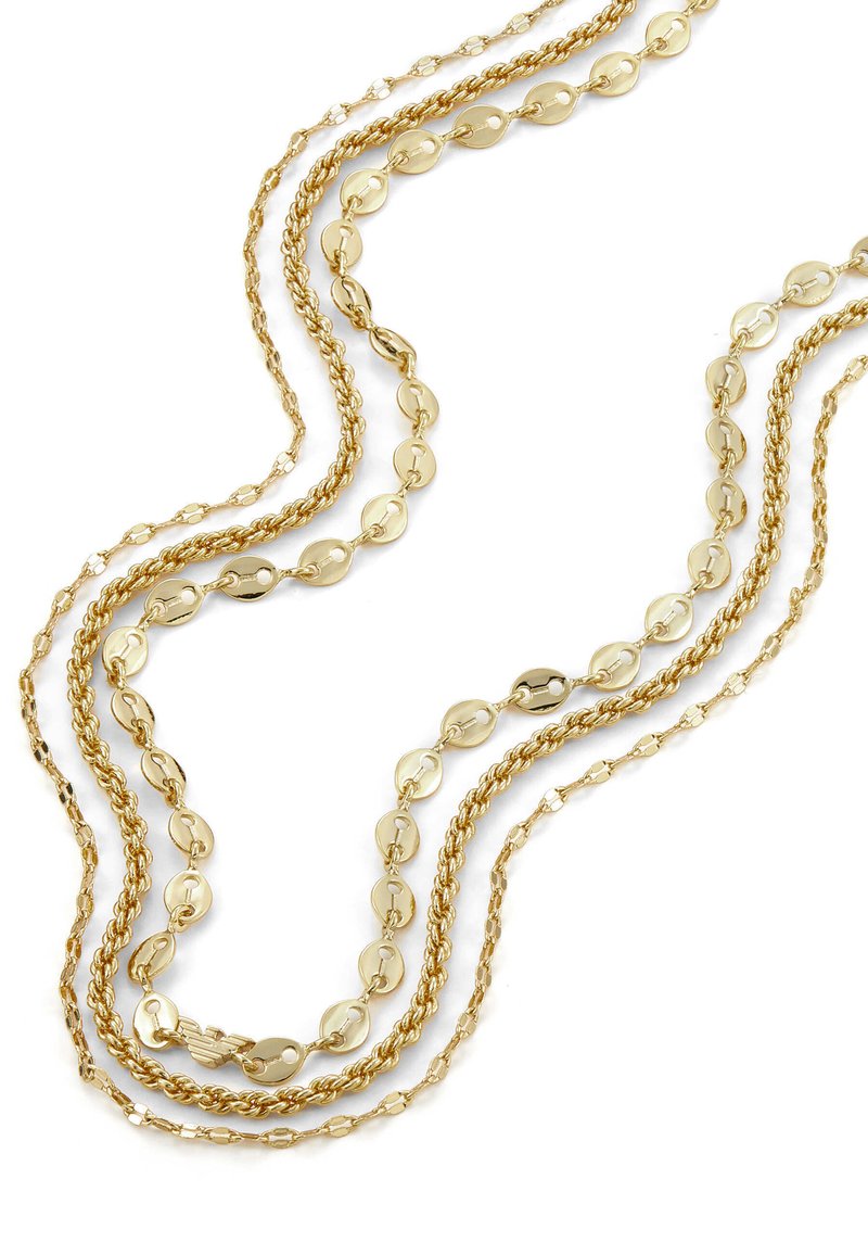 Tre collane d'oro a tre strati con diversi stili di catena, tra cui anelli ovali, corda attorcigliata e piccole maglie allungate su uno sfondo bianco.