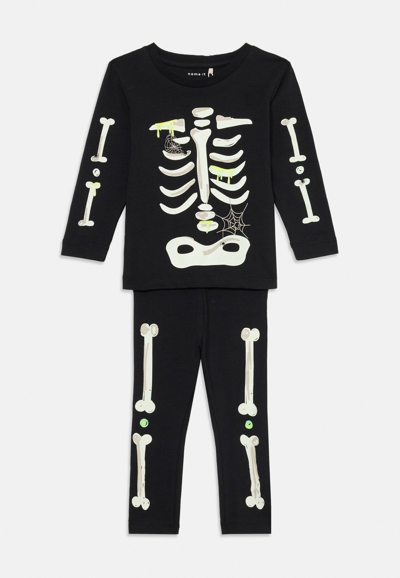 Schwarzes Langarmoberteil und Hose mit weißen Skelettknochen-Drucken, grüner Slime, der herabtropft, und Spinnennetzdetails für das Halloween-Kostüm von Kindern.