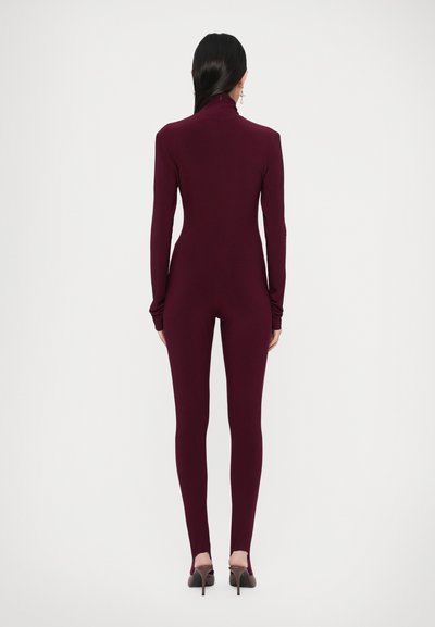 Vínové body s dlhými rukávmi a vysokým golierom, vyrobené z hladkej látky, priliehavý strih, doplnené čiernymi lodičkami na vysokom opätku.