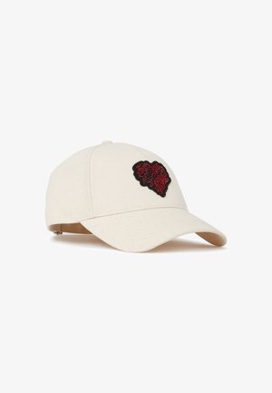 Off-white baseballkasket med en buet skygge og en rød og sort hjerteformet lap på frontpanelet.
