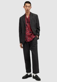Black blazer over a red floral shirt, black trousers, and black loafers with white socks. Simple design, lightweight fabric, button-up shirt.