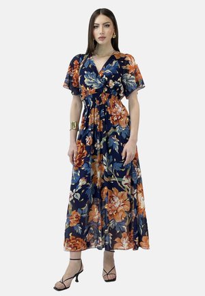 Abito lungo floreale blu navy con vivaci fiori arancioni e verdi, vita arricciata, maniche corte a volant e tessuto leggero.