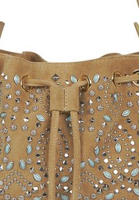 Bolso de cubo de ante color coñac que presenta piedras preciosas en plata y azul, con cierre de cordón y acentos decorativos de remaches en la superficie.