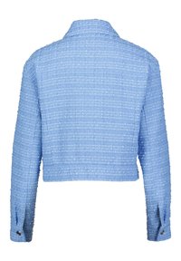 Blauwe textuurjack met een cropped ontwerp, lange mouwen en een kraag. Opvallend stippenpatroon met knoopaccenten op de mouwen.