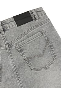 Szare dżinsy z czarną metką "Diverse Jeans", z kwadratową tylnią kieszenią i widocznymi detalami szwów.