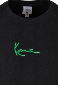 Tricou din bumbac negru cu guler rotund și mâneci scurte, având un logo semnat brodat de culoare verde aprins pe față.