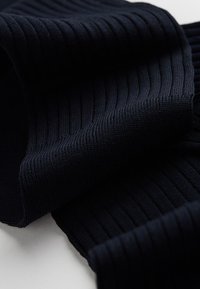 Mørkeblå ribbet stof med en blød tekstur. Har lodrette striber og en flydende fald, velegnet til forskellige tøjartikler.