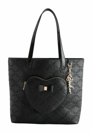 Black quilted tote bag with heart-shaped front pocket, black bow detail, and gold "Baker" script charm hanging from handle.