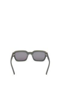 Neliömäiset aurinkolasit, joissa on tummanharmaa mattapinta, sävytetyt linssit ja hienovaraiset kultaiset yksityiskohdat yläreunassa. Sileä rakenne, nykyaikainen muotoilu.