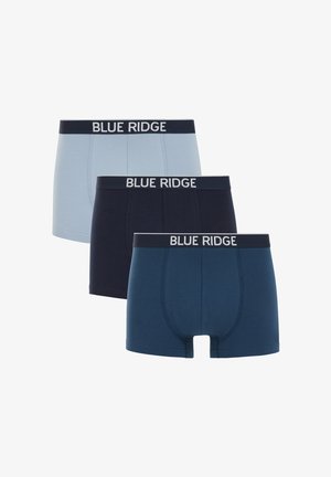 Ung mand stående uden skjorte iført marineblå Blue Ridge boxershorts mod en ensartet lys baggrund.