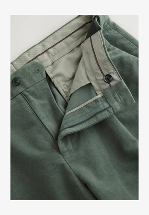 Pantalon en mélange de coton vert avec une texture lisse, doté d'une fermeture éclair et d'un bouton, d'une doublure en vert clair contrastant et de subtils détails de couture.