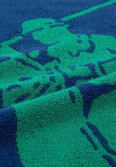 Μπλε και πράσινο ύφασμα από πετσέτα με αφηρημένο μοτίβο με υφασμένους βρόχους και πτυχώσεις σε κοντινή θέα.