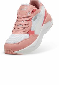 Puma tenisice koje sadrže kombinaciju ružičaste sintetičke kože i bijele mrežaste tkanine, okrugli vrh, podstavljeni ovratnik i teksturirana gumena potplata.