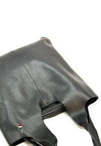 Zwarte lederen tote bag met een gestructureerde oppervlakte, open bovenkant en twee handvatten. Inclusief een kleine Hongaars vlagaccent nabij de rits.