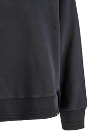 Dark gray sweatshirt with a crew neck, ribbed cuffs, and hem. Features a smooth texture and subtle branding detail near the bottom.