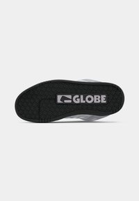 Sole of a black and gray shoe with floral tread pattern and "GLOBE" logo in bold letters at the center.