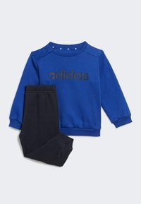 Felpa blu con logo "adidas" nero e bottoni a scatto sulla spalla, abbinata a pantaloni sportivi neri con vita elasticizzata. Tessuto liscio.