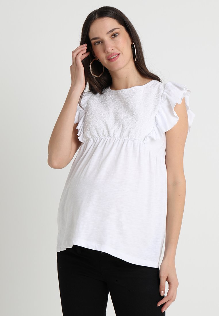 Blusa de maternidade branca com frente bordada, mangas curtas com babados e um corte descontraído. Tecido suave com decote redondo, estilo casual.