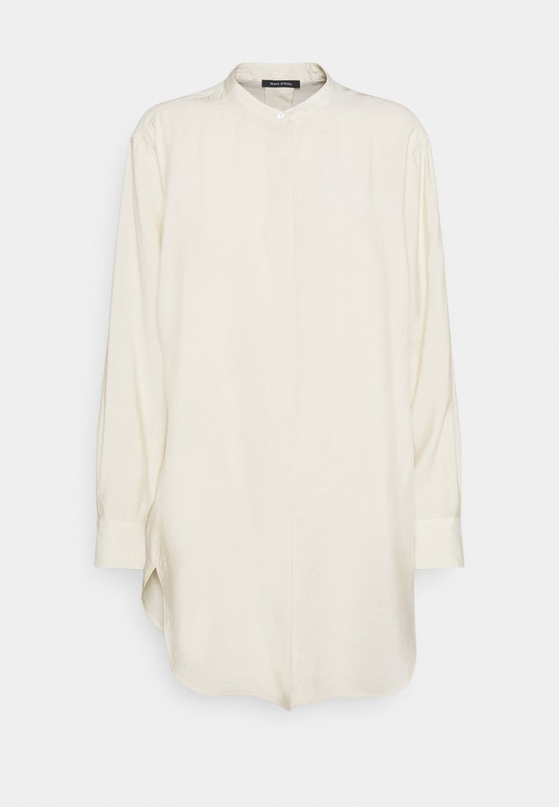 Lysebeige skjorte med lange ærmer, bandkrave, enkelt knaplukning og sidelommer for en afslappet pasform. Blødt stof med glat tekstur.