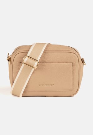 Beige tekstureret crossbody taske med front lomme, guldfarvet hardware og justerbar beige rem med hvid stribe.