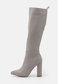 Bota de cuero gris hasta la rodilla con tacón cuadrado y bucle de tirón, con detalle de costura a lo largo de la costura trasera.