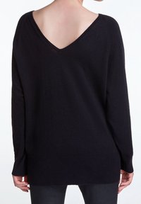 Pull en maille noire avec un décolleté en V profond et des manches longues, présentant une coupe légèrement ample et un ourlet côtelé. La vue arrière met en valeur la texture douce.