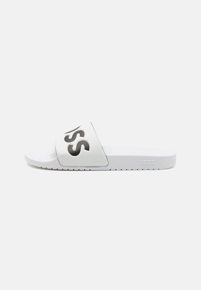 White slide sandal with a smooth strap featuring a dark logo. Textured sole, lightweight design, ideal for casual wear.