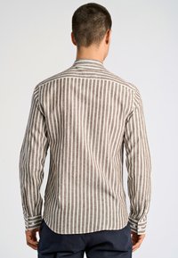 Camicia a maniche lunghe a righe marroni e bianche con orlo leggermente curvo e polsini abbottonati, realizzata in tessuto leggero.